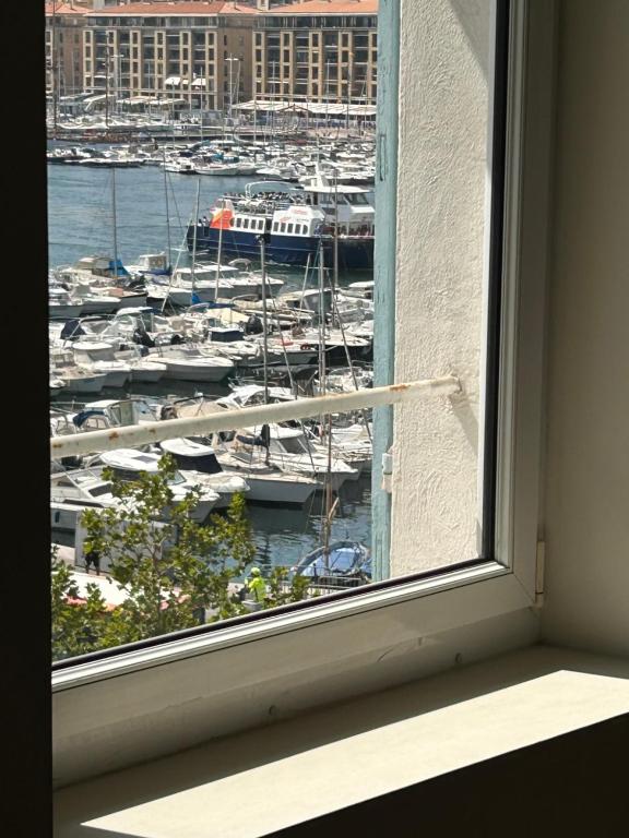 a window with a view of a harbor with boats at Standing Vieux port 110 m2, Marseille in Marseille