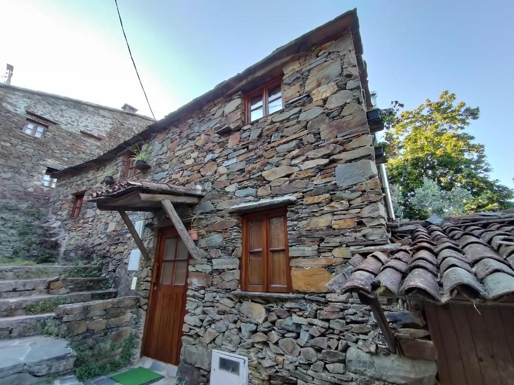 una antigua casa de piedra con puerta de madera en Casa da Esperança, en Lousã