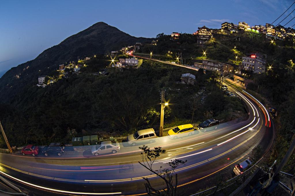 a busy road with cars on it at night at Shabby Home 28 in Jiufen