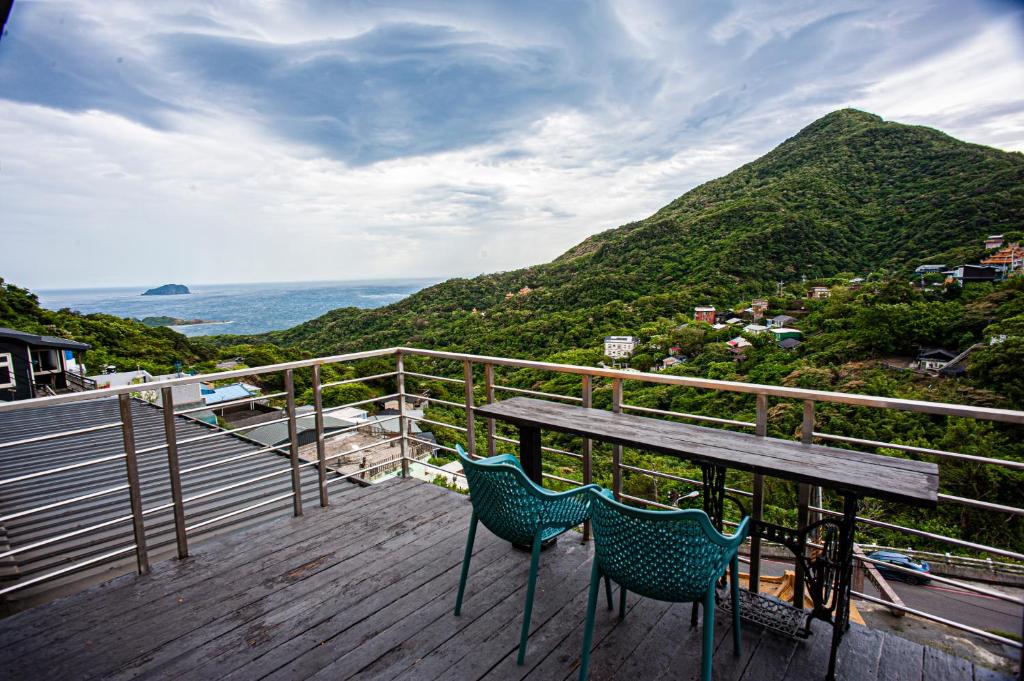 un tavolo e due sedie su una terrazza con una montagna di Shabby Home 28 a Jiufen