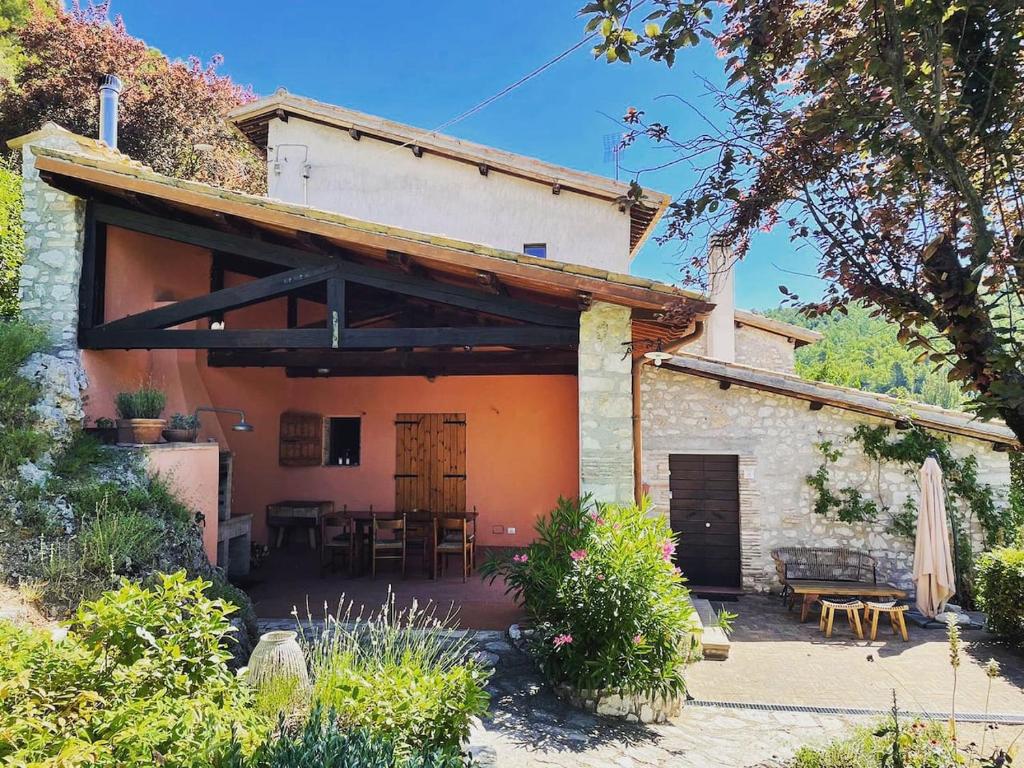 een huis met een terras met een tafel en stoelen bij Forca de Cerro in Spoleto