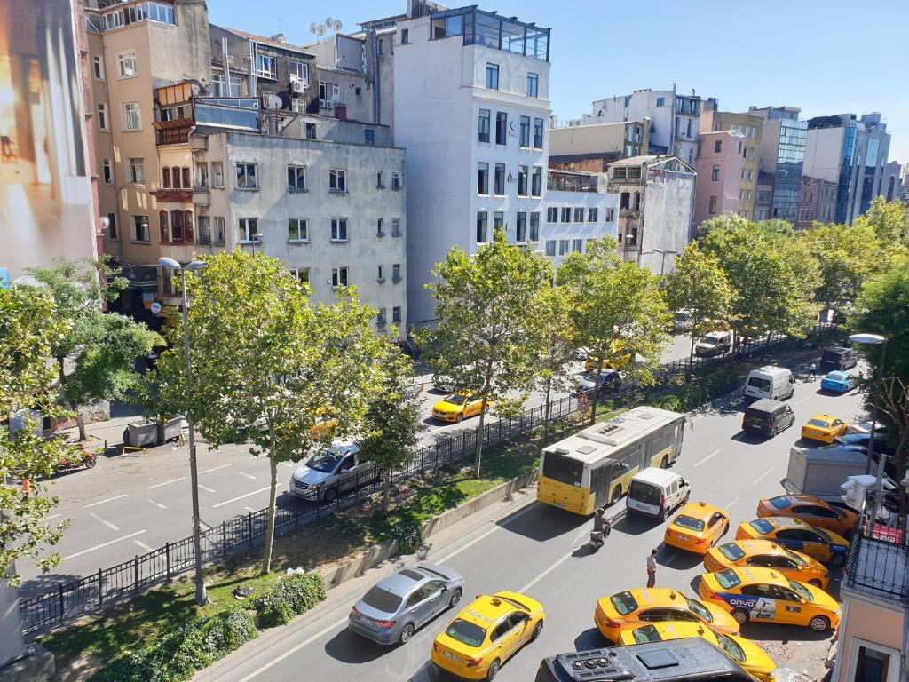 una concurrida calle de la ciudad llena de taxis y autobuses en Seven Suite Taksim en Estambul