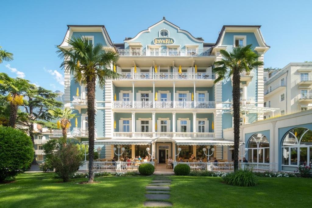 a large building with palm trees in front of it at Villa Bavaria in Merano