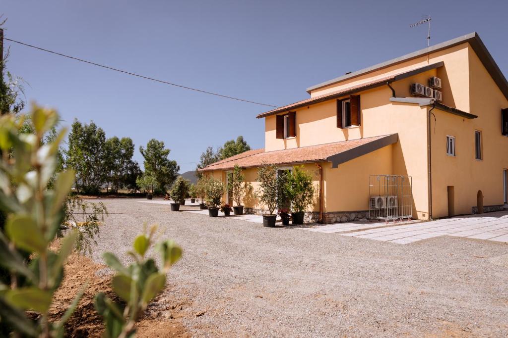 a building with a gravel driveway in front of it at Agriturismo Bio Podere 109 in Alberese