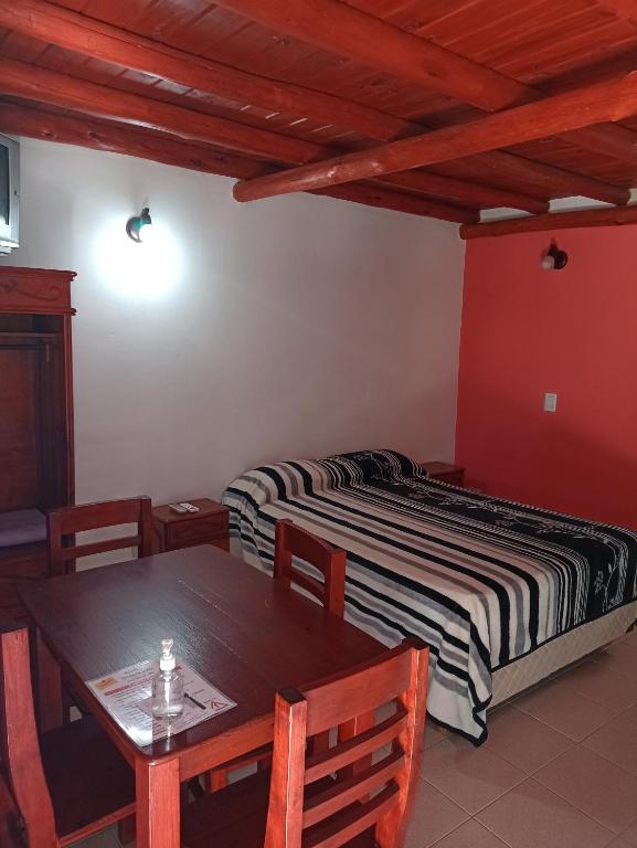 een slaapkamer met een bed en een tafel en stoelen bij MonoAmbientes Colon ER in San José