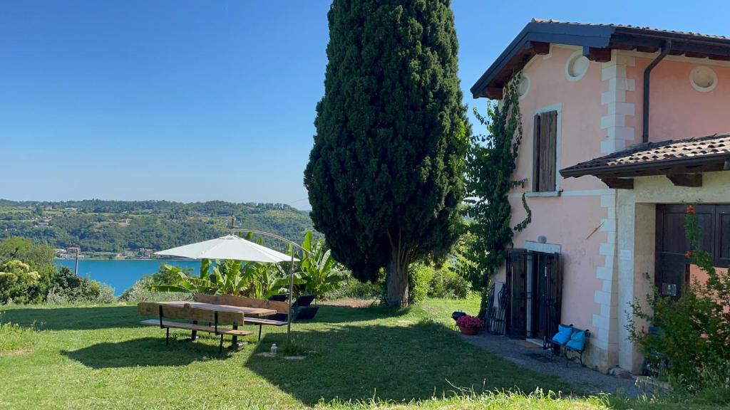 a house with a yard with a bench and an umbrella at Agriturismo Valsiniga - Your Private Family Retreat on Lake Garda Saló in Salò