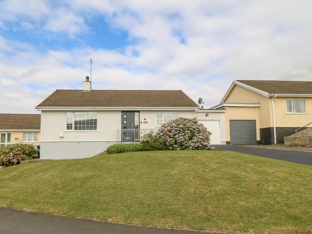 a house with a large lawn in front of it at Cynefin in Llangefni