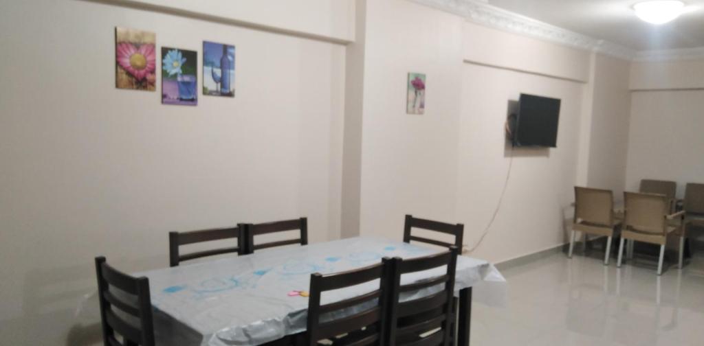 ein Esszimmer mit einem Tisch und Stühlen sowie einem TV in der Unterkunft عماره الاطباء in Alexandria