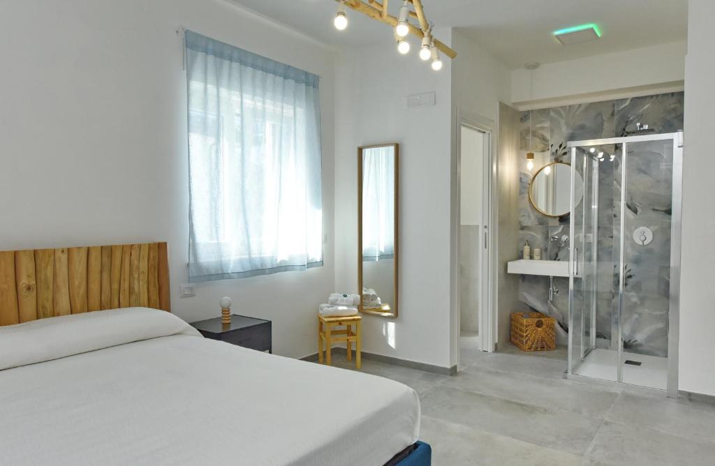 a bedroom with a bed and a glass shower at Luna Calante in Santa Maria di Castellabate