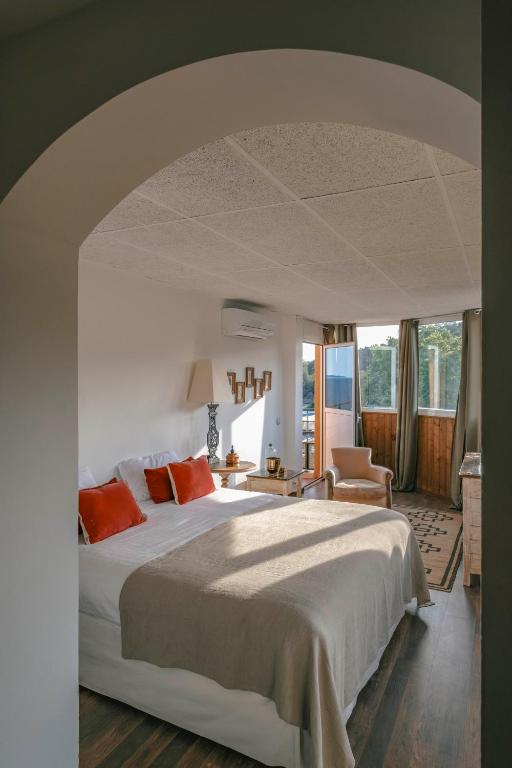 a bedroom with a large white bed with orange pillows at Surplage Hotel Cavalière in Le Lavandou