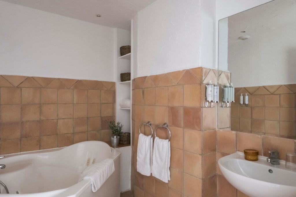 a bathroom with a tub and a sink at Surplage Hotel Cavalière in Le Lavandou