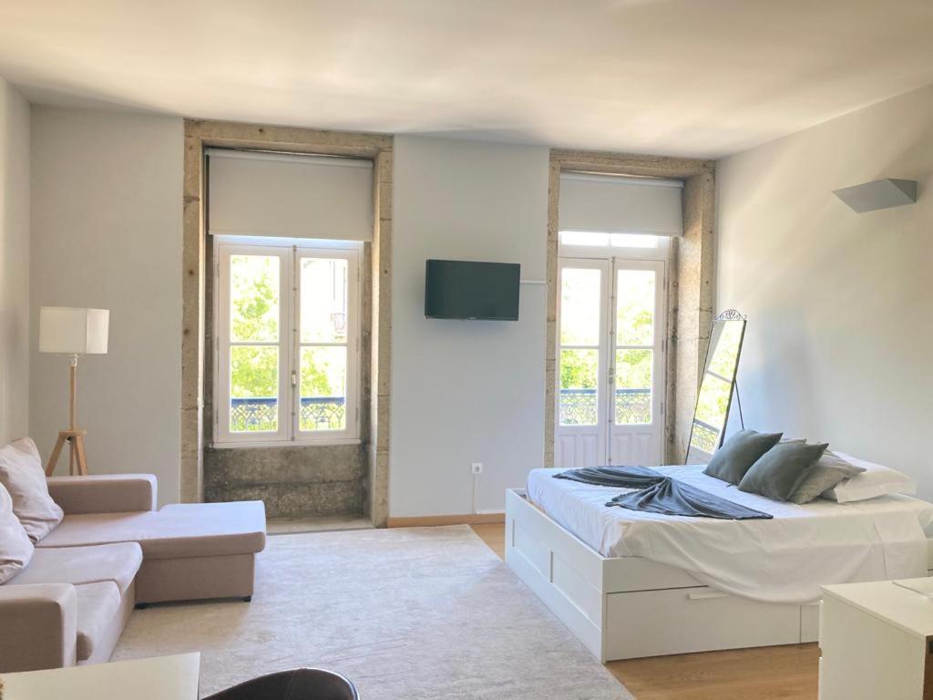 a white room with a bed and a couch at Coreto Bento Freitas in Vila do Conde