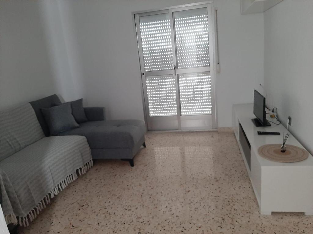- un salon avec un canapé et une télévision dans l'établissement Apartamento Juan, à Vejer de la Frontera
