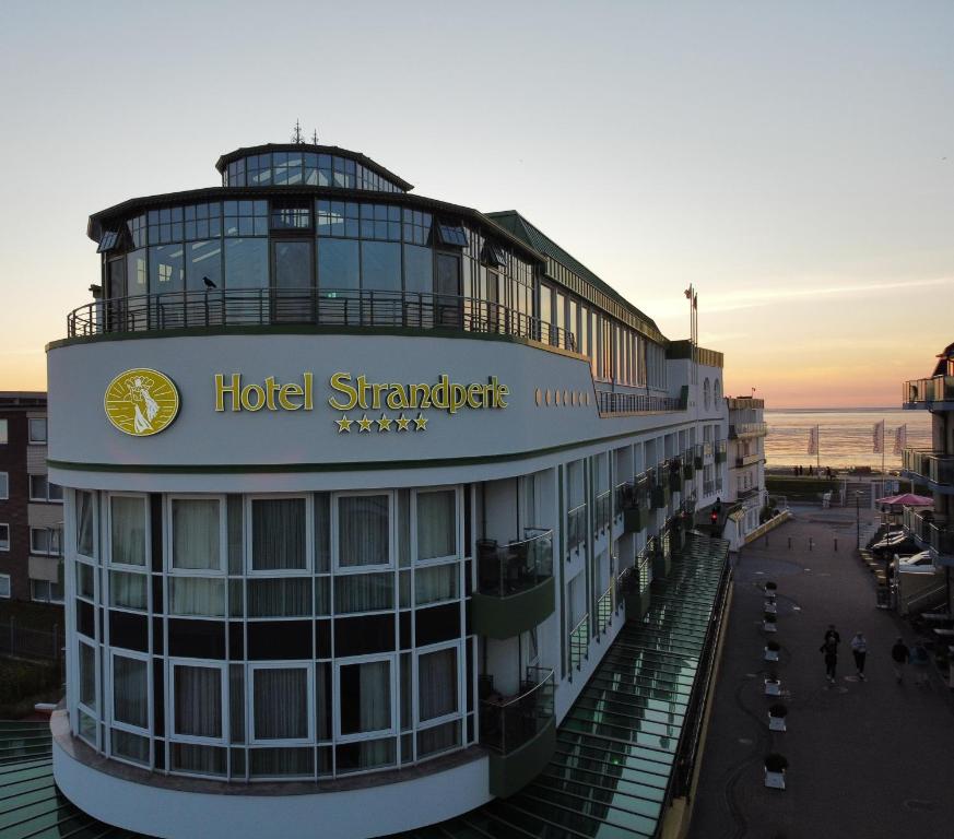 un hôtel shimizu avec un panneau sur un bâtiment dans l'établissement Hotel Strandperle, à Cuxhaven