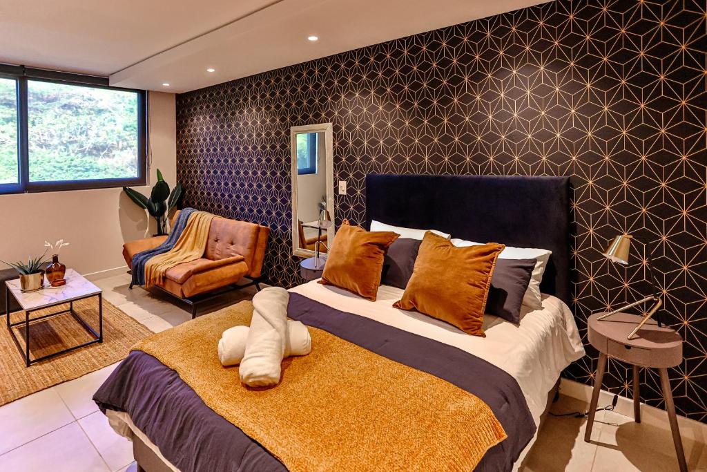 um quarto com uma cama grande e uma cadeira em Zimbali Lakes Boulevard Suites 218 em Ballito