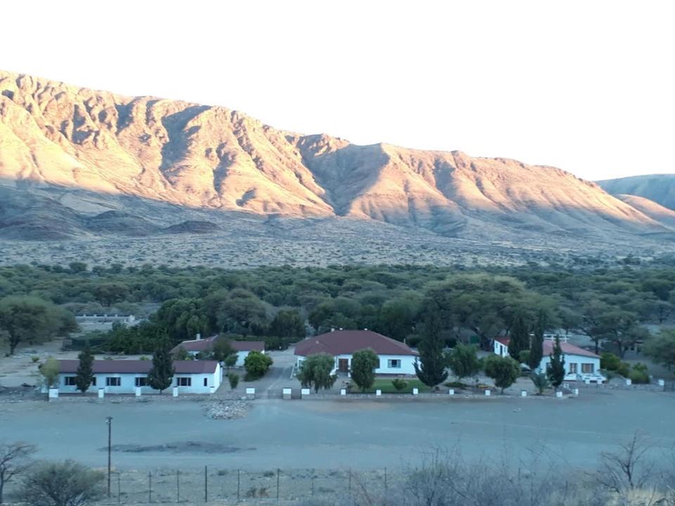 una casa frente a una montaña con un cuerpo de agua en BKZ Self-Catering, en Solitaire