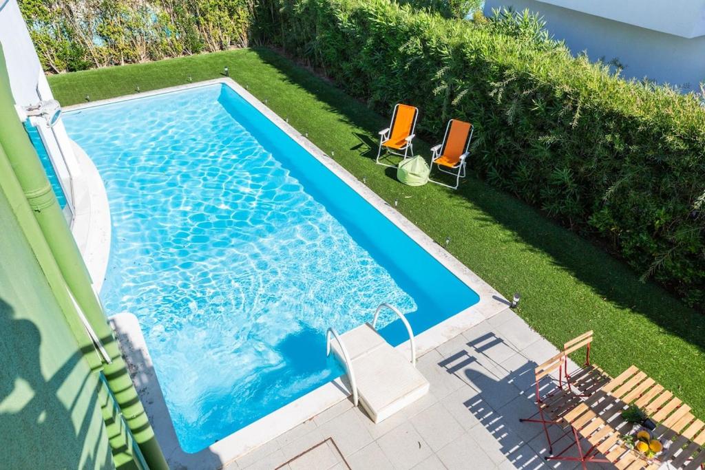 una vista aérea de una piscina con 2 sillas en 3 Bedroom Villa with Private Pool in Palmela, en Palmela