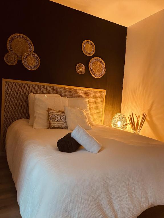 a bedroom with a large bed with white sheets and pillows at Le 8 in Romorantin