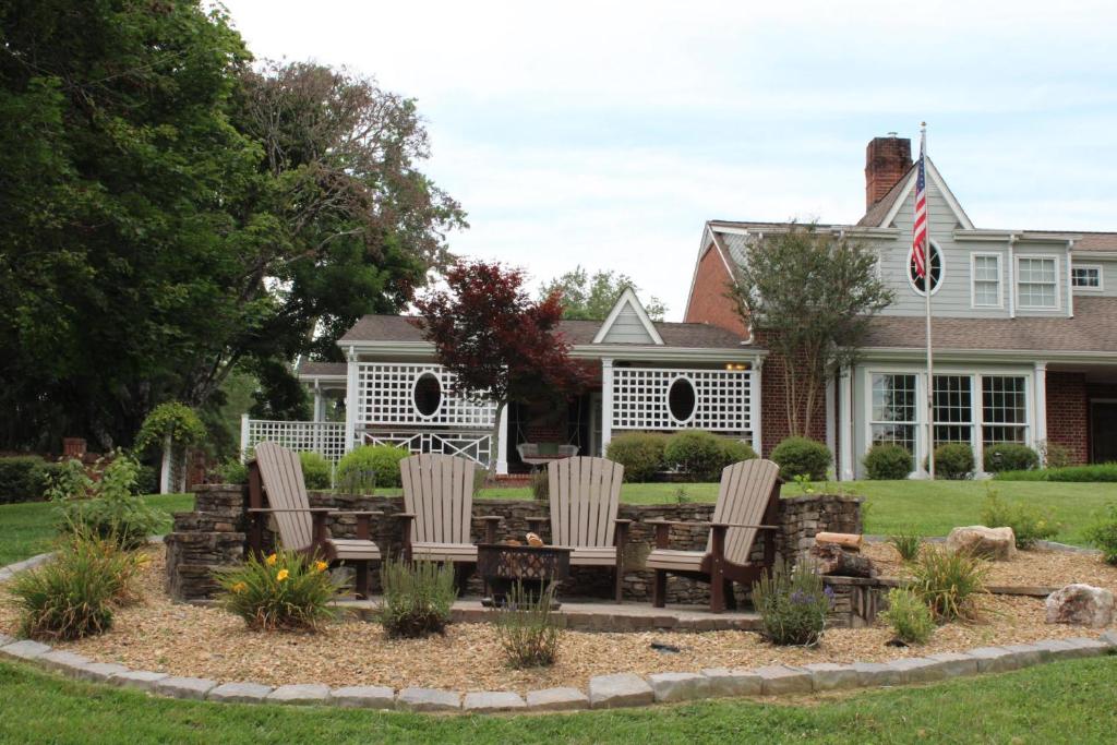 un patio con sillas y una mesa frente a una casa en The Emory House en Emory