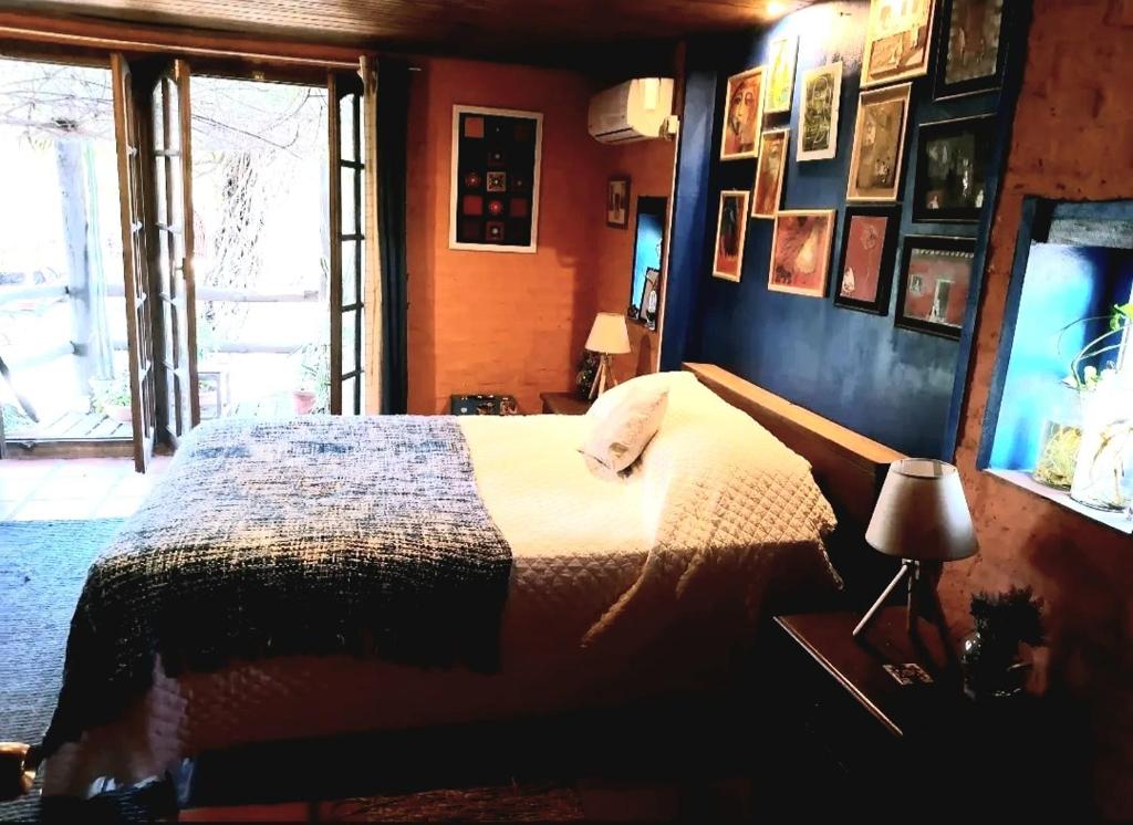 Schlafzimmer mit einem Bett und einem Fenster in der Unterkunft LA ESTANCIA HOSTEL COLONIA in Colonia del Sacramento
