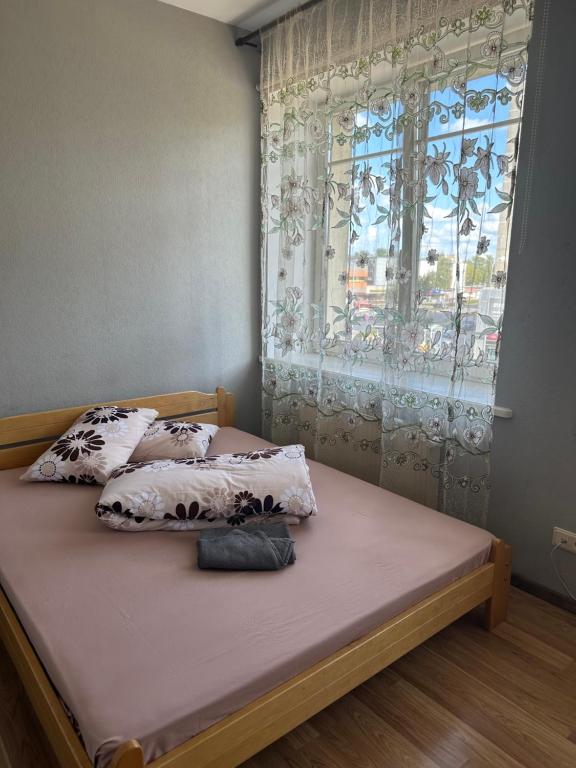 a bed with two pillows and a window in a bedroom at Paradize in Daugavpils