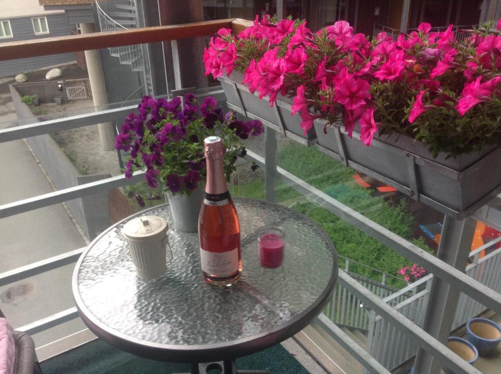 een fles wijn op een tafel naast bloemen bij Solsiden in Trondheim