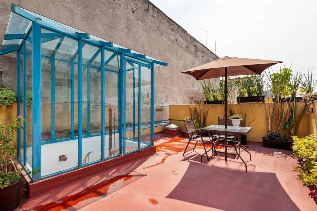 a patio with a table and an umbrella at Amazing loft w/ terrace in Mexico City Downtown in Mexico City