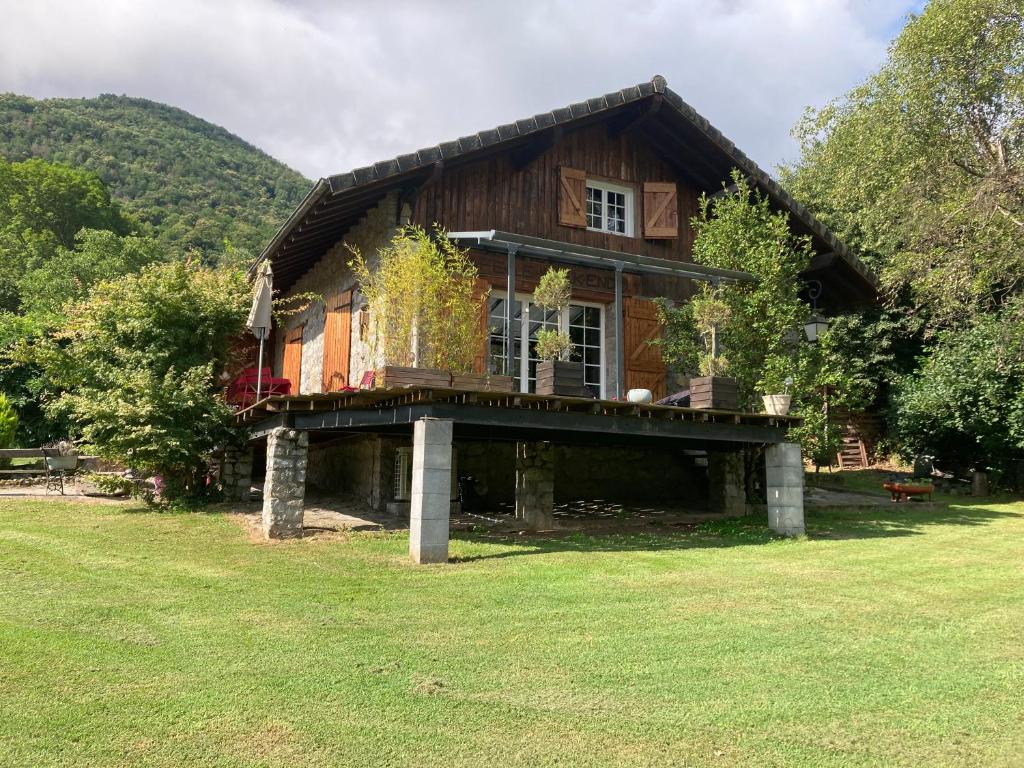 Cette grande maison en bois dispose d'une terrasse couverte sur une pelouse. dans l'établissement Chalet 09, à Albiès