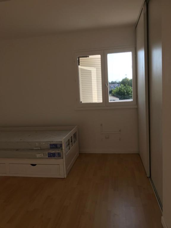 ein leeres Zimmer mit einem Bett und einem Fenster in der Unterkunft Villa 10 pers +Piscine + parking in Lattes