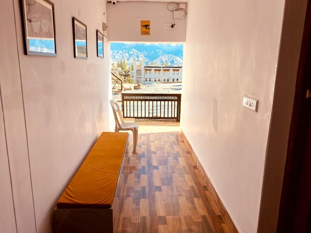 a room with a bench and a balcony with a view at Milam Hostel in Leh