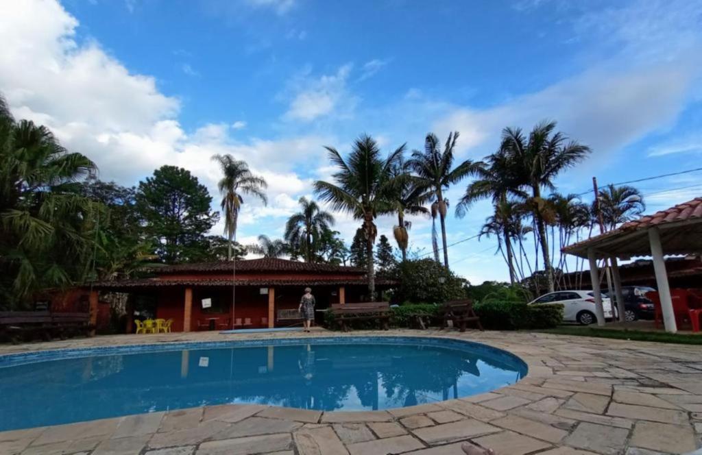 uma piscina em frente a uma casa com palmeiras em Sitio em Santa Isabel Recanto da Tranquilidade em Santa Isabel