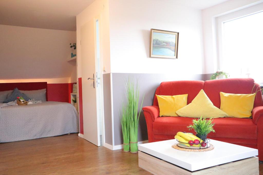 a living room with a red couch and yellow pillows at Ferienwohnung Helgoland in Dorum Neufeld