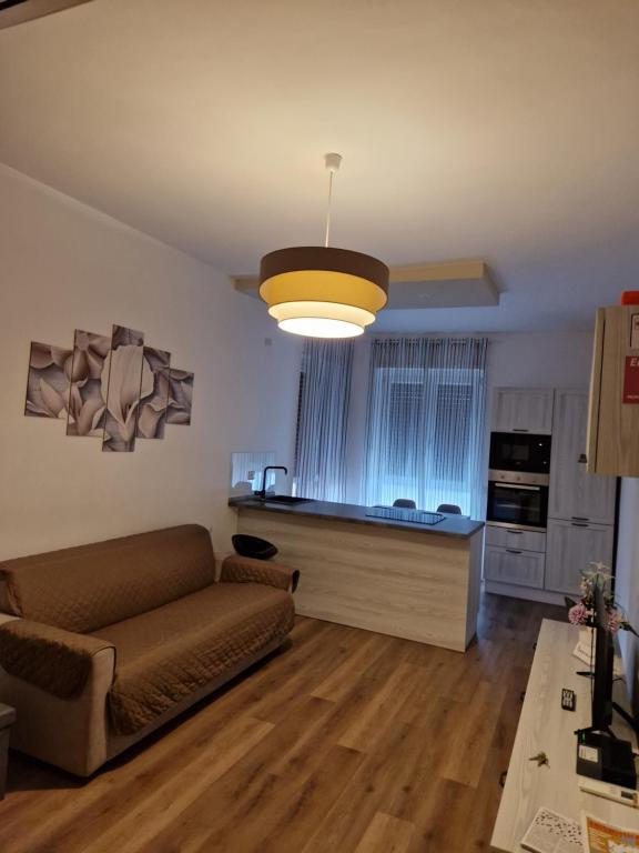 uma sala de estar com um sofá e uma cozinha em Appartamento Perla em Cologno Monzese