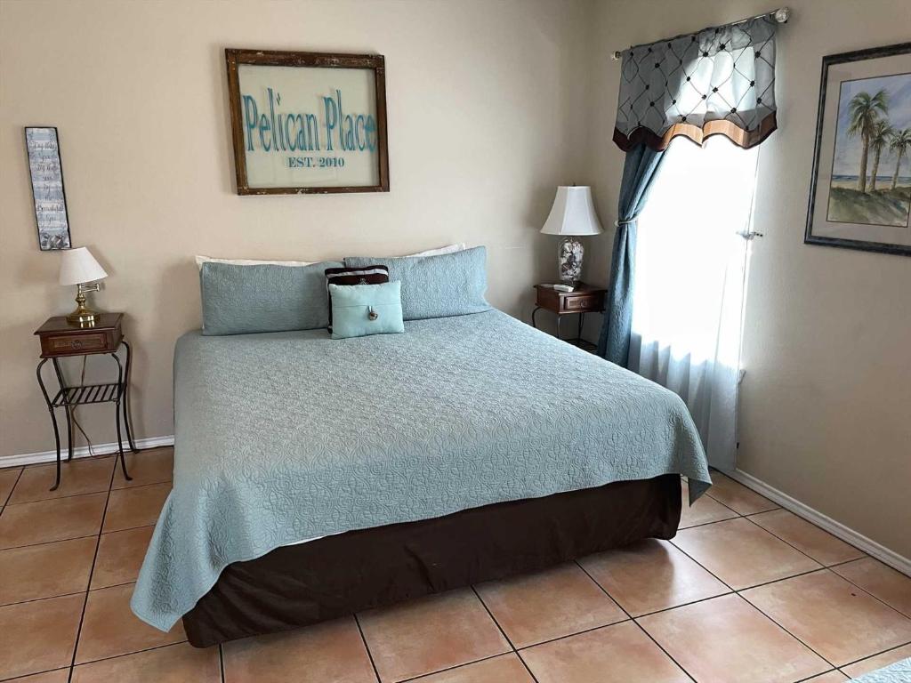a bedroom with a bed with blue pillows and a window at 126 E Pike home in South Padre Island