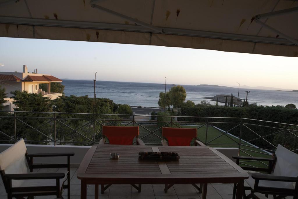 ein Tisch und Stühle auf einem Balkon mit Blick auf das Meer in der Unterkunft VILLA DEEP BLUE in Aghia Marina