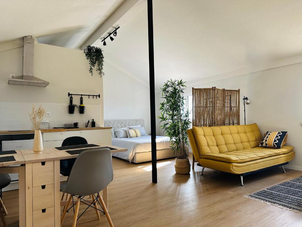 ein Wohnzimmer mit einem gelben Sofa und einem Tisch in der Unterkunft Refúgio das Carquejas 