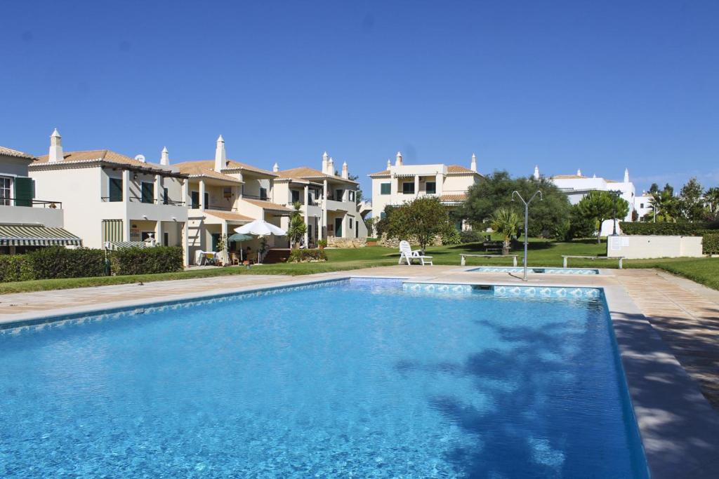 a swimming pool in front of some houses at Condominio Vilita, T1-Lt-5,F Pera-Silves in Pêra