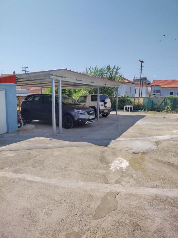 a parking lot with a carport with cars parked in it at Sofia's House in Néa Tríglia