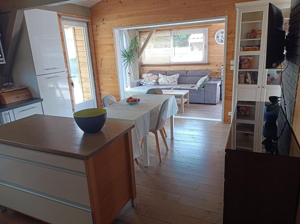 a kitchen and living room with a table and a couch at MAISON &amp; PISCINE PRIVES,PLAGES OCEAN ET LAC A 10 kms in Linxe