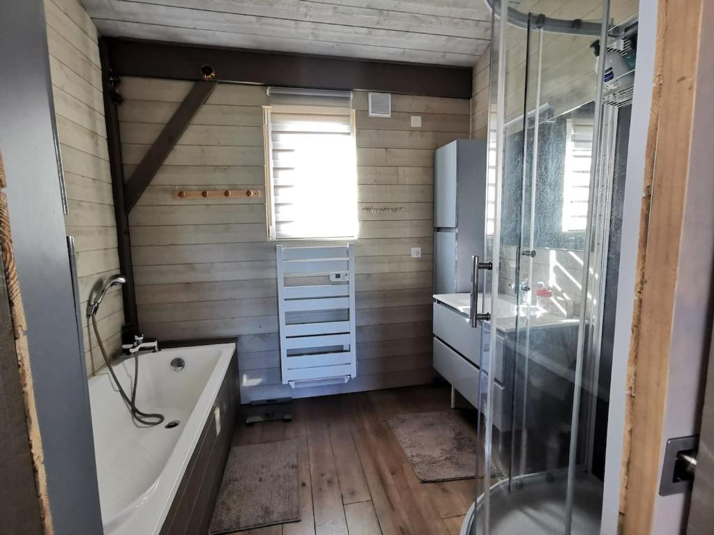 a bathroom with a tub and a shower and a sink at MAISON &amp; PISCINE PRIVES,PLAGES OCEAN ET LAC A 10 kms in Linxe