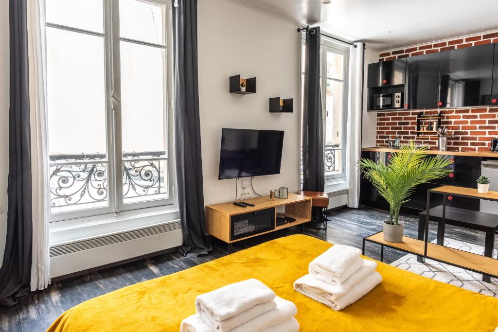 巴黎Design Studio near metro and Eiffel Tower的带床和电视的客厅