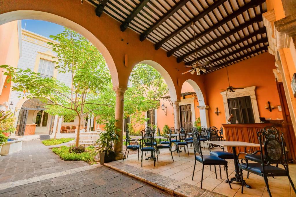 an outdoor patio with a table and chairs at Hotel Boutique La Mision De Fray Diego in M&eacute;rida