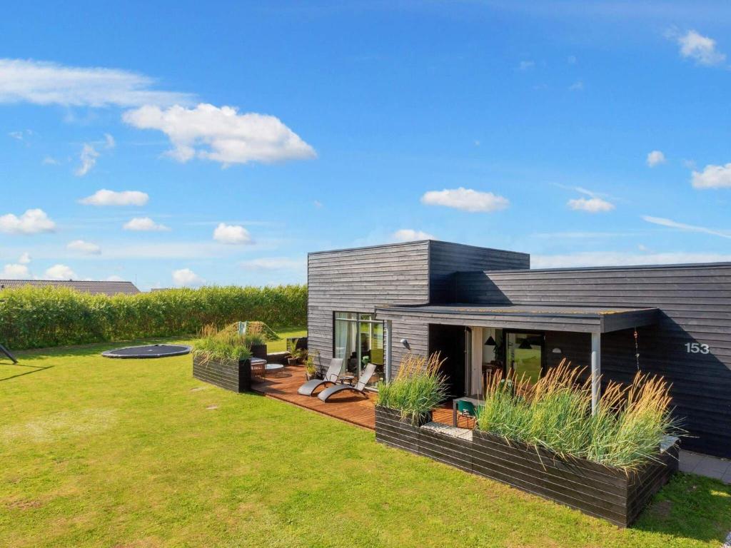 ein modernes Haus mit Garten mit Rasen in der Unterkunft Captivating Holiday home in L kken with Whirlpool in Løkken