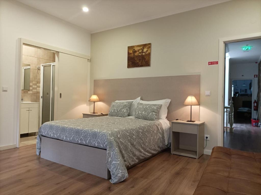 1 dormitorio con 1 cama y 2 mesas con lámparas en HOSPEDARIA LONDRES, en Oporto