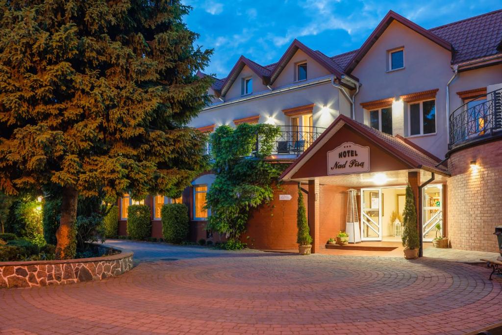 un hotel con entrada frente a un edificio en Hotel Nad Pisą, en Pisz