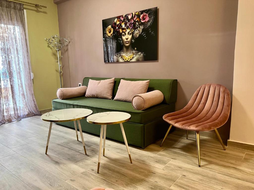 a living room with a green couch and two tables at Loutraki apARTment in Loutraki