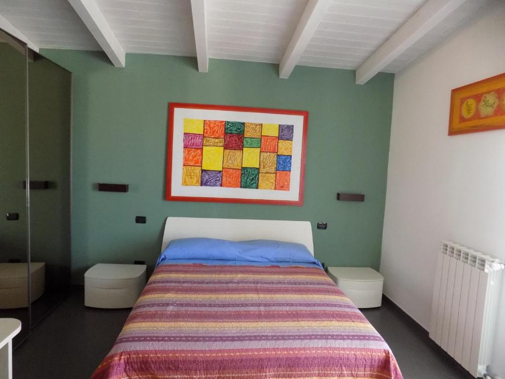 a bedroom with a bed and a painting on the wall at Attico Stazione - Montello 16 in Bari