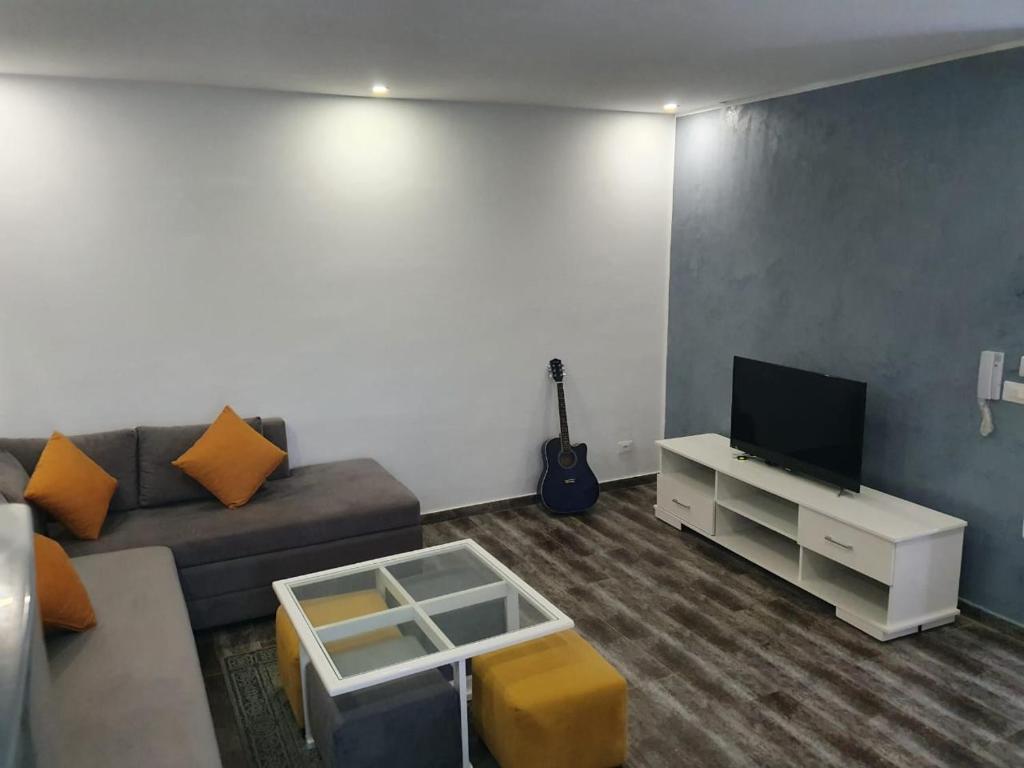 uma sala de estar com um sofá e uma televisão em جنان الحمامات اقامة em Hammamet