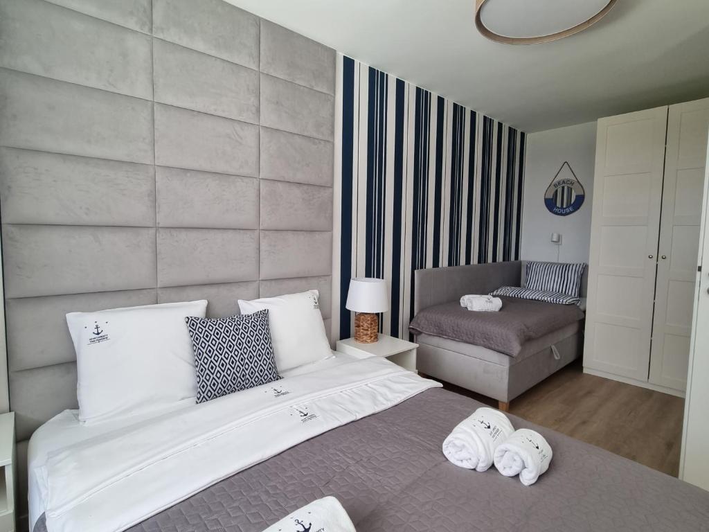 a bedroom with a large bed with towels on it at Apartamenty Marynarskie AP10 in Debina
