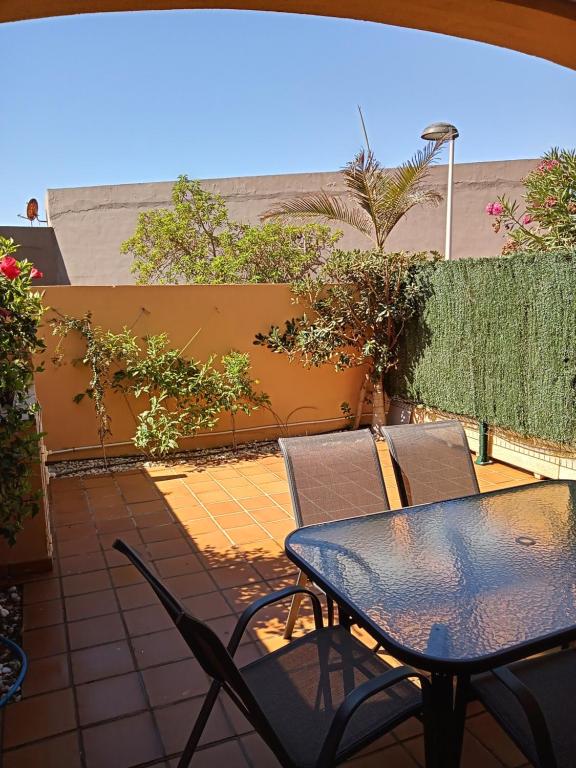 Una mesa y sillas en un patio. en Apartamento 1 HOME SUITES ALMERÍA, en Almería